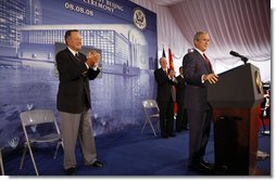 President George W. Bush acknowledges applause after being introduced by former President George H.W. Bush Friday, Aug. 8, 2008, during dedication ceremonies at the U.S. Embassy in Beijing. Said the President, "This has got to be a historic moment: father and son, two Presidents, opening up an embassy. I suspect it's the first, although I must confess I haven't done a lot of research into the itinerary of the Adams boys." White House photo by Eric Draper