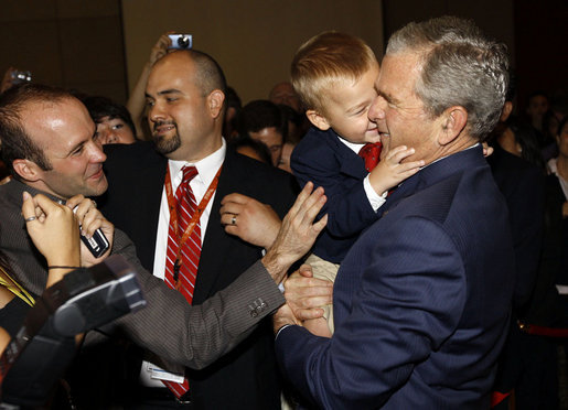 President George W. Bush is hugged by a young boy Friday, Aug. 8, 2008, during a greeting at the U.S. Embassy in Beijing. White House photo by Eric Draper