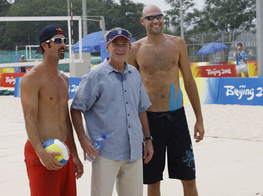 President George W. Bush pauses with U.S. Men's Beach Volleyball's Todd Rogers, left, and Philip Dalhausser as he visited the practice session Saturday, Aug. 9, 2008, at Beijing's Chaoyang Park prior to their first matches of the 2008 Summer Olympic Games. White House photo by Eric Draper