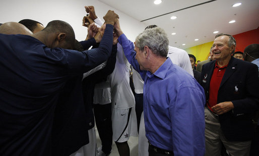 President George W. Bush huddles with members of the U.S. Olympic Men's Basketball Team Sunday, Aug. 10, 2008, during a visit with the team prior to their game against China at the 2008 Summer Olympic Games in Beijing. Former President George H.W. Bush is seen at right. White House photo by Eric Draper