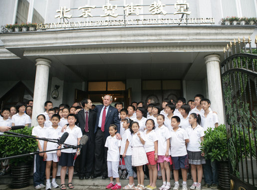 Standing with the Kuanjie Summer Vacation School Choir and Pastor Meng Maoru, President George W. Bush delivers a statement outside Beijing Kuanjie Protestant Christian Church in Beijing Sunday, Aug. 10, 2008. Said the President, "Laura and I just had the great joy and privilege of worshiping here in Beijing, China. You know, it just goes to show that God is universal, and God is love, and no state, man or woman should fear the influence of loving religion." White House photo by Chris Greenberg