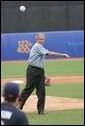 President George W. Bush throws out the first pitch to the U.S. Olympic men's baseball team catcher Lou Marson before a practice game against the Chinese Olympic men's baseball team Monday, Aug. 11, 2008, at the 2008 Summer Olympic Games in Beijing. White House photo by Chris Greenberg