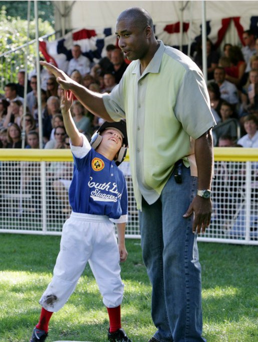 A player for the Stars reaches up to give a high-five to former New York Yankees All-Star player Bernie Williams, the first base coach at the Tee Ball on the South Lawn: A Salute to the Troops game between the Stars and Stripes, Sunday, Sept. 7, 2008, played by the children of active-duty military personnel. White House photo by Chris Greenberg