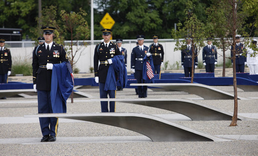 Soldiers hold ceremonial cloths that were draped over the 184 memorial benches, each honoring all innocent life lost when American Airlines Flight 77 crashed into the Pentagon on Sept. 11, 2001, during the dedication of the 9/11 Pentagon Memorial Thursday, Sept. 11, 2008, in Arlington, Va. White House photo by Eric Draper