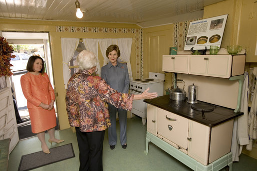 Mrs. Laura Bush receives an explanation of the scale of author Laura Ingalls Wilder's kitchen from Mrs. Jean Coday, Director and President of the Laura Ingalls Wilder Historic Home and Museum in Mansfield, Mo., Oct. 3, 2008. Accompanying the two on the tour is Mrs. Melanie Blunt, First Lady of Missouri. Wilder is one of Mrs. Bush's favorite writers and she was surprised to see the petite kitchen, built to function for the 4-foot-10-inch author. White House photo by Chris Greenberg