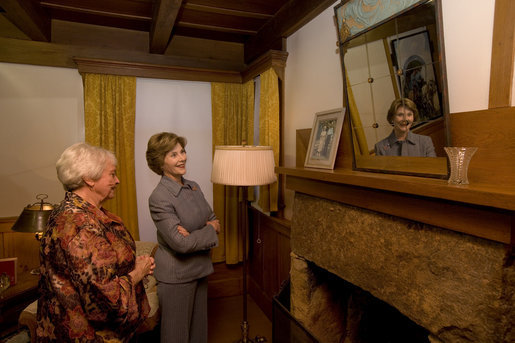 Mrs. Laura Bush looks at a portrait of Laura Ingalls Wilder and her husband on the Wilder home mantle Oct. 3., 2008, in Mansfield, Mo. Laura Ingalls married Almanzo Wilder in the summer of 1885 and moved to the Mansfield home where the "Little House" book series was written in 1894. Mrs. Jean Cody, Director and President of the Laura Ingalls Wilder Historic Home and Museum, explains that the mantle was something that the author really wanted to have. Her husband objected but obviously finally gave in. Wilder, who has been read by children and adults for over 70 years, is one of Mrs. Bush's favorite authors. The visit was used to help encourage American's to read their classic literature which defines us as a nation, reflects our history and bring us together by expressing our shared ideals. White House photo by Chris Greenberg