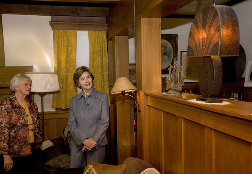 Mrs. Laura Bush admires a steel lamp at the Mansfield, Mo., home of Laura Ingalls Wilder. Mrs. Jean Coday, Director and President of the Laura Ingalls Wilder Historic Home and Museum, explains that the lamp originally belonged to the well-known author's sister. This week the Laura Ingalls Wilder Historic Home and Museum was designated a Save America's Treasures project. White House photo by Chris Greenberg