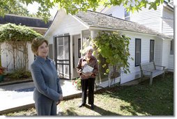 Mrs. Laura Bush talks with press outside the Mansfield, Mo., home of author Laura Ingalls Wilder after Mrs. Jean Coday, Director and President of the Laura Ingalls Wilder Historic Home and Museum, offered the First Lady a tour of the modest home. The home was designated this week as a Save America's Treasures project, which is in partnership with the National Trust for Historic Preservation. Mrs. Bush noted that Wilder, who wrote the "Little House" book series, was one of her favorite authors. "My mother read them to me when I was little before I could read," she said. White House photo by Chris Greenberg