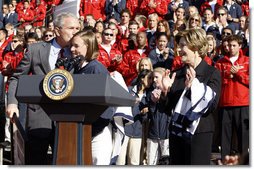 President George W. Bush kisses Army Lieutenant Melissa Stockwell, Paralympian and Iraq war veteran, after she presents President Bush and Mrs. Laura Bush with the American Flag that flew over the Olympic Village in Beijing following his remarks to members of the 2008 United States Summer Olympic and Paralympic Teams Tuesday, Oct. 7, 2008, on the South Lawn of the White House.  White House photo by Eric Draper