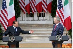 President George W. Bush listens as Italian Prime Minister Silvio Berlusconi addresses his remarks at a joint press availability Monday, Oct. 13, 2008, in the White House Rose Garden. Prime Minister Berlusconi said that Italy and America share a special friendship which has its roots in common values, in sharing a world which is inspired by love for democracy and freedom. White House photo by Chris Greenberg