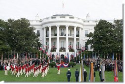 President George W. Bush and Prime Minister Silvio Berlusconi stand together on the reviewing stand Monday, Oct. 13, 2008 on the South Lawn of the White House, as the Old Guard Fife and Drum Corps passes in review during the arrival ceremony to welcome Prime Minister Berlusconi to the White House. White House photo by Chris Greenberg