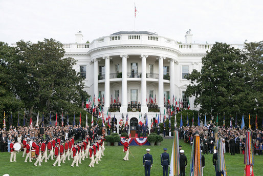 President George W. Bush and Prime Minister Silvio Berlusconi stand together on the reviewing stand Monday, Oct. 13, 2008 on the South Lawn of the White House, as the Old Guard Fife and Drum Corps passes in review during the arrival ceremony to welcome Prime Minister Berlusconi to the White House. White House photo by Chris Greenberg