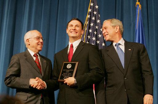 President George W. Bush and U.S. Attorney General Michael Mukasey congratulate FBI special agent graduate Richard Brooks, center, after he is presented with the Director's Leadership Award Thursday, Oct. 30, 2008, during the graduation ceremony for FBI special agents in Quantico, Va. White House photo by Joyce N. Boghosian