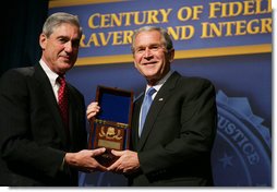 President George W. Bush is presented with an honorary FBI Special Agent credential by FBI Director Robert Mueller Thursday, Oct. 30, 2008, at the graduation ceremony for FBI special agents in Quantico, Va. White House photo by Joyce N. Boghosian