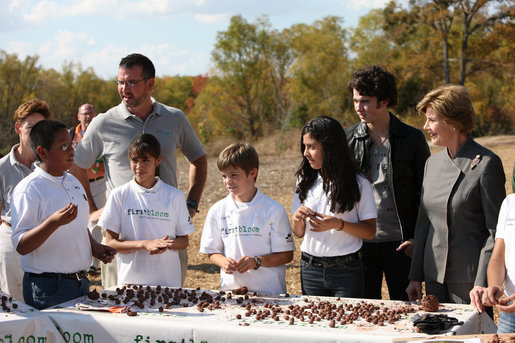 Mrs. Laura Bush listens as a child tells her about making seed balls speaks during a First Bloom Event at Trinity River Audubon Center, Sunday, November 2, 2008 in Dallas, TX. Mrs. Bush is joined by Benjamin Jones, Director of Education, Trinity River Audubon Center, left and singer/songwriter Kevin Jonas of the Jonas Brothers, right. White House photo by Chris Greenberg