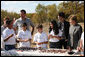 Mrs. Laura Bush listens as a child tells her about making seed balls speaks during a First Bloom Event at Trinity River Audubon Center, Sunday, November 2, 2008 in Dallas, TX. Mrs. Bush is joined by Benjamin Jones, Director of Education, Trinity River Audubon Center, left and singer/songwriter Kevin Jonas of the Jonas Brothers, right. White House photo by Chris Greenberg