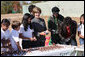 Surrounded by children Mrs. Laura Bush practices making seed balls during a First Bloom event at the Trinity River Audubon Center, Sunday, November 2, 2008, in Dallas, TX. Mrs. Bush is joined by singer/songwriters the Jonas Brothers, Kevin Jonas, Joe Jonas, and Nick Jonas, right. White House photo by Chris Greenberg