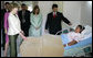 Mrs. Laura Bush spends a moment with Ms. Robalba Robinson, a breast cancer patient recovering from recent reconstructive surgery, during a visit Friday, Nov. 21, 2008, to the National Oncology Institute in Panama City. Joining her is Mrs. Vivian Fernandez de Torrijos, First Lady of Panama, in pink, and Dr. Rosario Turner, Panama's Minister of Health. The man at right is unidentified. White House photo by Joyce N. Boghosian