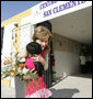 Mrs. Laura Bush hugs a young girl after she was presented with a bouquet of flowers upon her arrival welcome to the San Clemente Health Center Friday, Nov. 21, 2008, in San Clemente, Peru. Mrs. Bush visited the center and participated in interactive demonstrations depicting community-based health training. White House photo by Joyce N. Boghosian