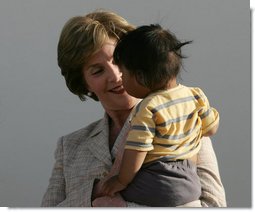 Mrs. Laura Bush smiles as she holds a child during a visit Friday, Nov. 21, 2008, to the San Clemente Health Center in San Clemente, Peru. The center serves an average of 80 patients a day in the town of 25,000 located six miles north of Pisco, the site of the August 2007, 8.0-magnitude earthquake. White House photo by Joyce N. Boghosian