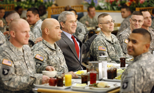 President George W. Bush is flanked by Sgt. First Class Rick Elza, left, of Lexington, Ky., and Capt. Rolando Perez of Mayaguez, Puerto Rico, as he sits for lunch Tuesday, Nov. 25, 2008, at Fort Campbell's Son Cafe. White House photo by Eric Draper