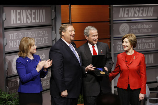 President George W. Bush, joined by Mrs. Laura Bush, is presented with the International Medal of PEACE by Pastor Rick Warren and his wife, Kay Warren, left, Monday, Dec. 1, 2008, following their participation at the Saddleback Civil Forum on Global Health in Washington, D.C. White House photo by Eric Draper