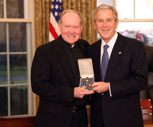 President George W. Bush stands with Father Tim Scully, CSC, after presenting him with the 2008 Presidential Citizens Medal Wednesday, Dec. 10, 2008, in the Oval Office of the White House. White House photo by Chris Greenberg