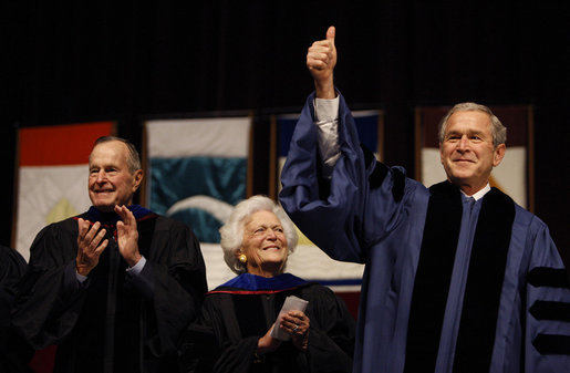 With former President George H.W. Bush and Mrs. Barbara Bush looking on, President George W. Bush gives the thumbs-up to the audience as he stands onstage Friday, Dec. 12, 2008, in Reed Arena where he delivered the commencement address at Texas A& M University in College Station, Texas. White House photo by Eric Draper