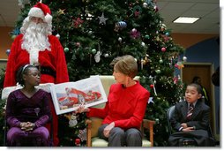 Mrs. Laura Bush reads "My Penguin Osbert" Monday, Dec. 15, 2008 to a gathering of patients and their families at Children's National Medical Center in Washington, D.C. Sitting with her are patient escort volunteers Dania Jecty, left, age 11, and Elmer Reyes, age 13.  White House photo by Joyce N. Boghosian