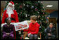 Mrs. Laura Bush reads "My Penguin Osbert" Monday, Dec. 15, 2008 to a gathering of patients and their families at Children's National Medical Center in Washington, D.C. Sitting with her are patient escort volunteers Dania Jecty, left, age 11, and Elmer Reyes, age 13. White House photo by Joyce N. Boghosian