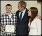 President George W. Bush congratulates U.S. Army PFC Joseph Devan of Baltimore, Md., after presenting him with a Purple Heart Monday, Dec. 22, 2008, during a visit to Walter Reed Army Medical Center, where the soldier is recovering from injuries suffered in Operation Iraqi Freedom. With them is PFC Devan's wife, Stephanie. White House photo by Eric Draper