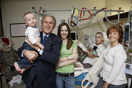 President George W. Bush holds 15-month-old James Jensen, son of Purple Heart recipient U.S. Army Cpl. Isaac Jensen of Layton, Utah, background-right, while posing for a photo Monday, Dec. 22, 2008 with Cpl. Jensen, his wife, Bethany and his mother, Eva Francis, right, during President Bush's visit to Walter Reed Army Medical Center in Washington, D.C. Jensen is recovering from injuries sustained while serving in support of Operation Iraqi Freedom. White House photo by Eric Draper