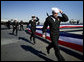 The crew of the USS George H.W. Bush (CVN 77) aircraft carrier ceremonially run aboard as the ship "comes alive" Saturday, Jan. 10, 2009, during commissioning ceremonies in Norfolk, Va. White House photo by David Bohrer