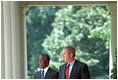 President George W. Bush and President Thabo Mbeki of South Africa walk along the colonnade to a joint press conference in the Rose Garden June 26, 2001. President Bush and President Mbeki agree that economic freedom and political freedom must go hand-in-hand to sustain peace and security.