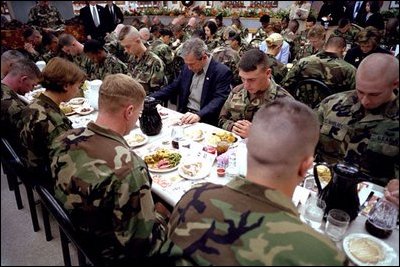 President George W. Bush prays with troops before sharing Thanksgiving dinner at Fort Campbell, Ky., Nov. 21, 2001. "This Thanksgiving, Americans are especially thankful for our freedom," said the President. And we are especially thankful to you, the people who keep us free."