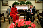 President George W. Bush and Coretta Scott King, the widow of Dr. Martin Luther King, Jr., share a laugh in the Oval Office Jan. 21, 2002. President George W. Bush honored Dr. King in a White House celebration and received a portrait of the civil rights leader from his wife and children in the East Room.