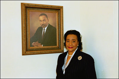 Coretta Scott King poses next to the portrait of her late husband, Dr. Martin Luther King, in the East Colonnade of the White House in Feb. 25, 2004.