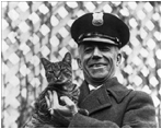 Officer Benjamin Fink holds Tige, the Coolidge's cat, at the White House on March 25, 1924. 