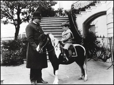 A White House policeman helps young Quentin Roosevelt by holding the reins of Algonquin, a calico pony, in 1902.