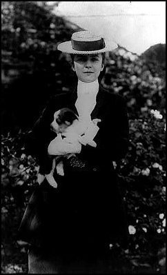 Theodore Roosevelt's oldest child, Alice, holds her dog on the White House lawn, June 17, 1902. Alice also owned a snake, which died a suspicious death at the hands of one of her siblings. 