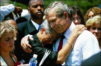 President George W. Bush hugs a woman attending the Annual Peace Officers' Memorial Service at the U.S. Capitol in Washington, D.C., Saturday, May 15, 2004. "I also thank all the family members who have come to Washington for this service. For each of you, there is a name on the National Law Enforcement Officers Memorial that will always stand apart. You feel the hurt of loss and separation, but I hope that you don't feel alone," said the President. 