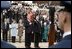 Placing his hand over his heart, President George W. Bush participates in the Wreath Laying Ceremony at the Tomb of the Unknowns in Arlington Cemetery on Veterans Day Nov. 11, 2003. Laura Bush is pictured standing behind the President.