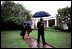 President George W. Bush departs the White House under a spring shower May 9, 2003. He is followed by Chief of Staff Andrew Card, left, and National Security Advisor Dr. Condoleezza Rice. 