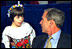 Attending a luncheon at the American-Polish Cultural Center in Troy, Mich., President Bush and President Kwasniewski are visited by one of the center’s smaller members. Upon their arrival to the center, the two presidents were greeted by about two dozen children wearing traditional clothing. White House photo by Eric Draper. 