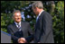 Approaching the podium, President Kwasniewski greets President Bush. "We are grateful to America, you, Mr. President, and your predecessors, for good will and help we have been receiving in Poland for dozen of years -- in all our efforts," said President Kwasniewski, addressing the crowd in English. "Poland is steadfast ally of the United States. We take over the co-responsibility for European and global security. On the 11th of September, all of us felt New Yorkers." White House photo by Susan Sterner. 