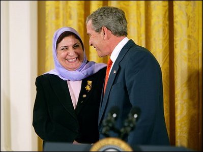 President George W. Bush greets Dr. Raja Habib Khuzai of the Iraqi Governing Council after delivering remarks on Women's Human Rights in the East Room of the White House Friday, March 12, 2004.