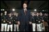 President George W. Bush stands on stage during his introduction before speaking on the war on terror at the Roswell Convention Center in Roswell, New Mexico, Thursday, Jan. 22, 2004.