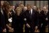 President George W. Bush escorts former First Lady Nancy Reagan to her seat before the funeral service for former President Ronald Reagan at the National Cathedral in Washington, DC on June 11, 2004. 