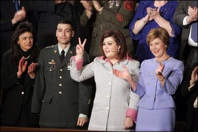 Safia Taleb al-Suhail, leader of the Iraqi Women's Political Council, second on right, displays a peace sign as other guests applaud during President George W. Bush's State of the Union speech at the U.S. Capitol, Wednesday, Feb. 2, 2005. Also pictured are, from left, Kindergarten teacher Lorna Clark of Santa Theresa, New Mexico, Army Staff Sergeant Norbert Lara, and Laura Bush. 