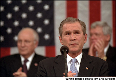 Pausing as the crowd applauds, President Bush delivers his State of the Union address to a joint session of Congress and the nation Jan. 29. White House photo by Eric Draper.